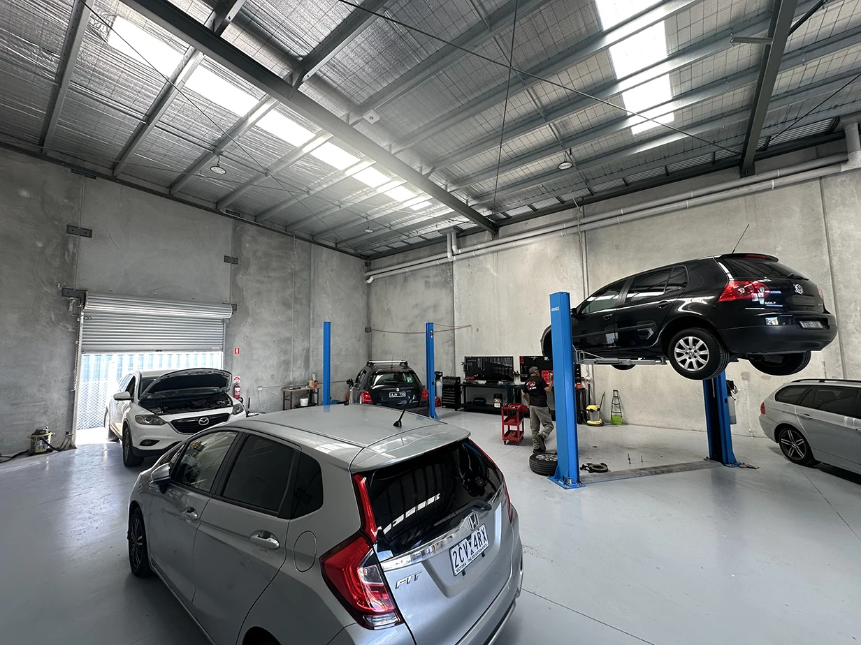Cars on hoists inside the 13 Automotive workshop